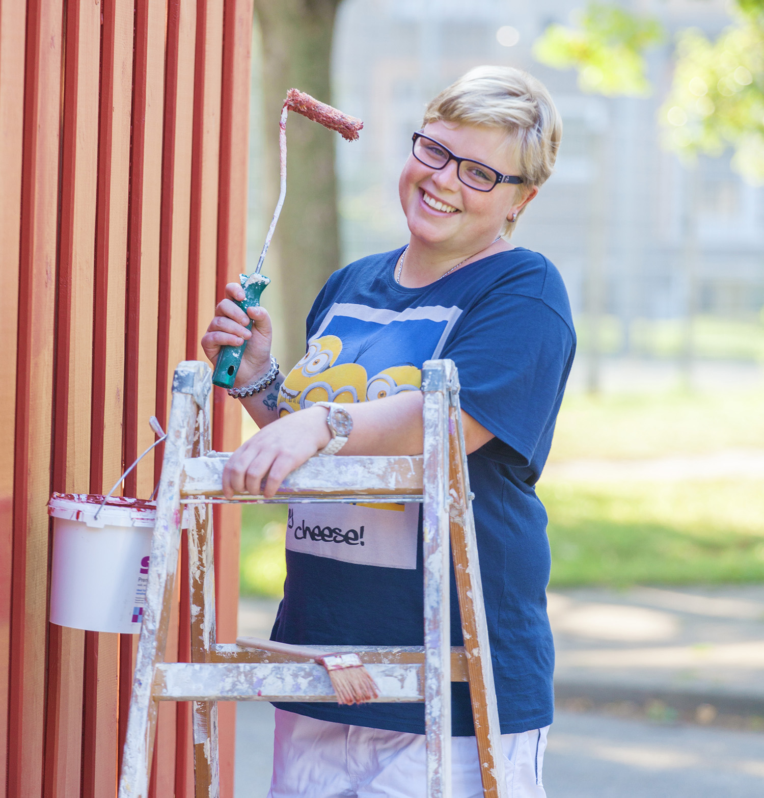 Eine Frau mit Behinderung streicht eine Wand.