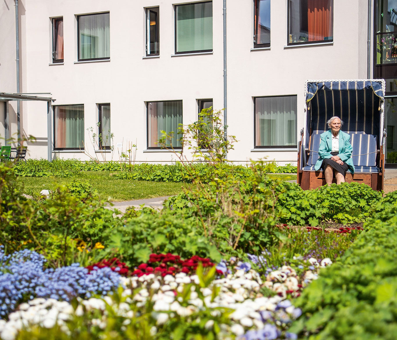 Eine Pflegebedürftige sitzt im Strandkorb vor der Einrichtung der Seniorenpflege in Travemünde.